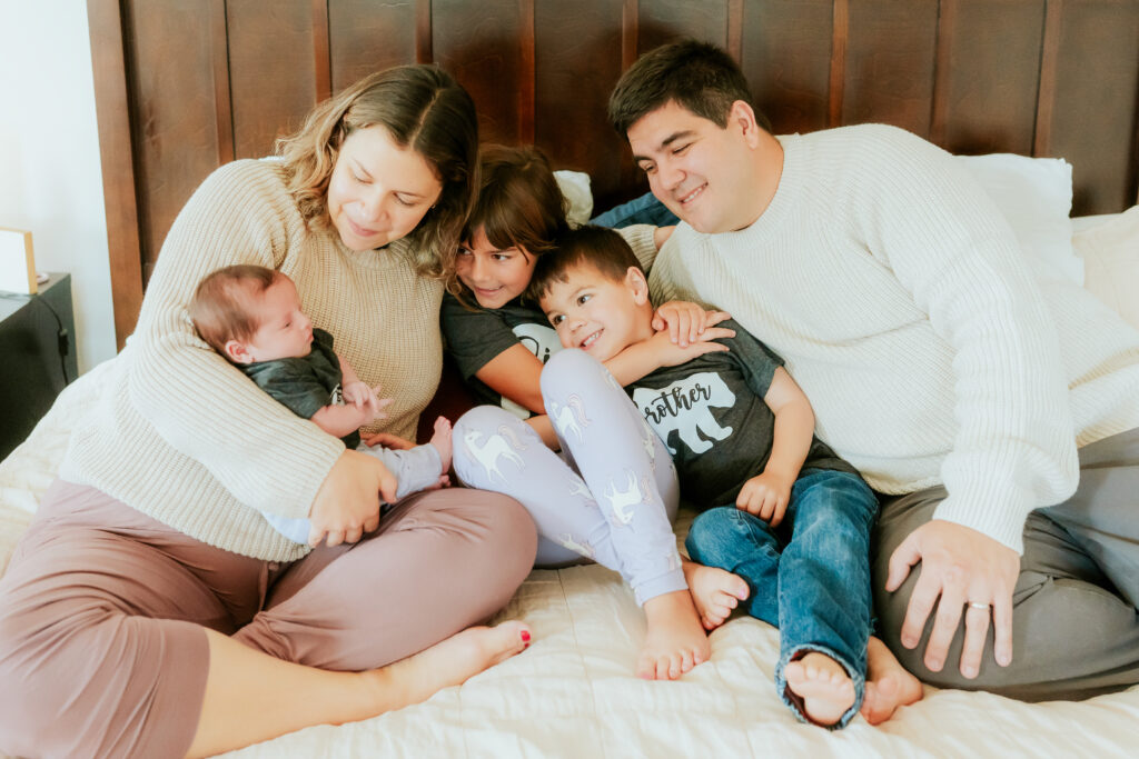 family of 5 together on a bed