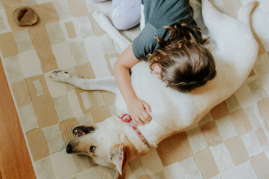 girl laying on the floor with a dog