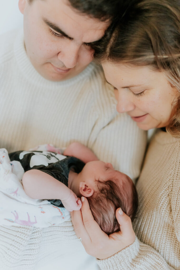 mom and dad looking down at a newborn baby